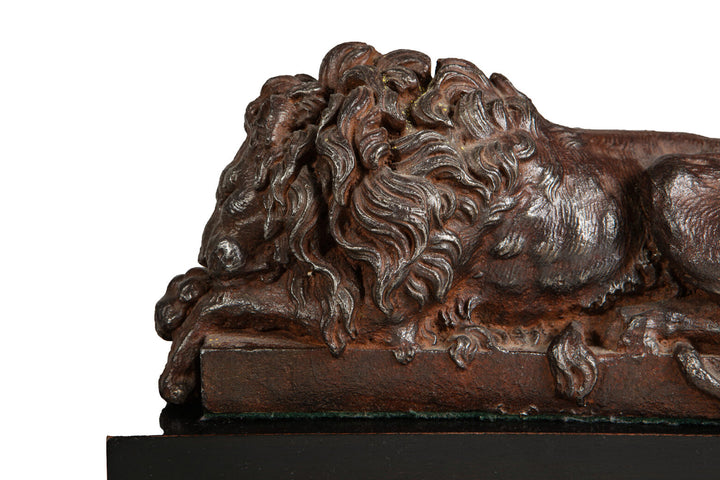 Pair of Cast Iron Versions of the Canova Lions sculpture showing a detailed sleeping lion with bronze patina.