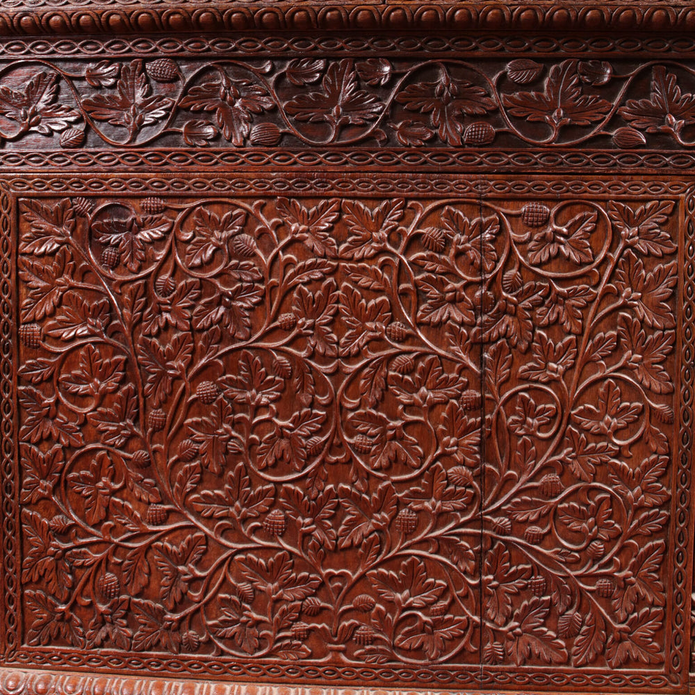 Anglo Indian Teak Pedestal Desk detailed with intricate carved scrolling vines, leaves, and fruit motifs on teak wood.