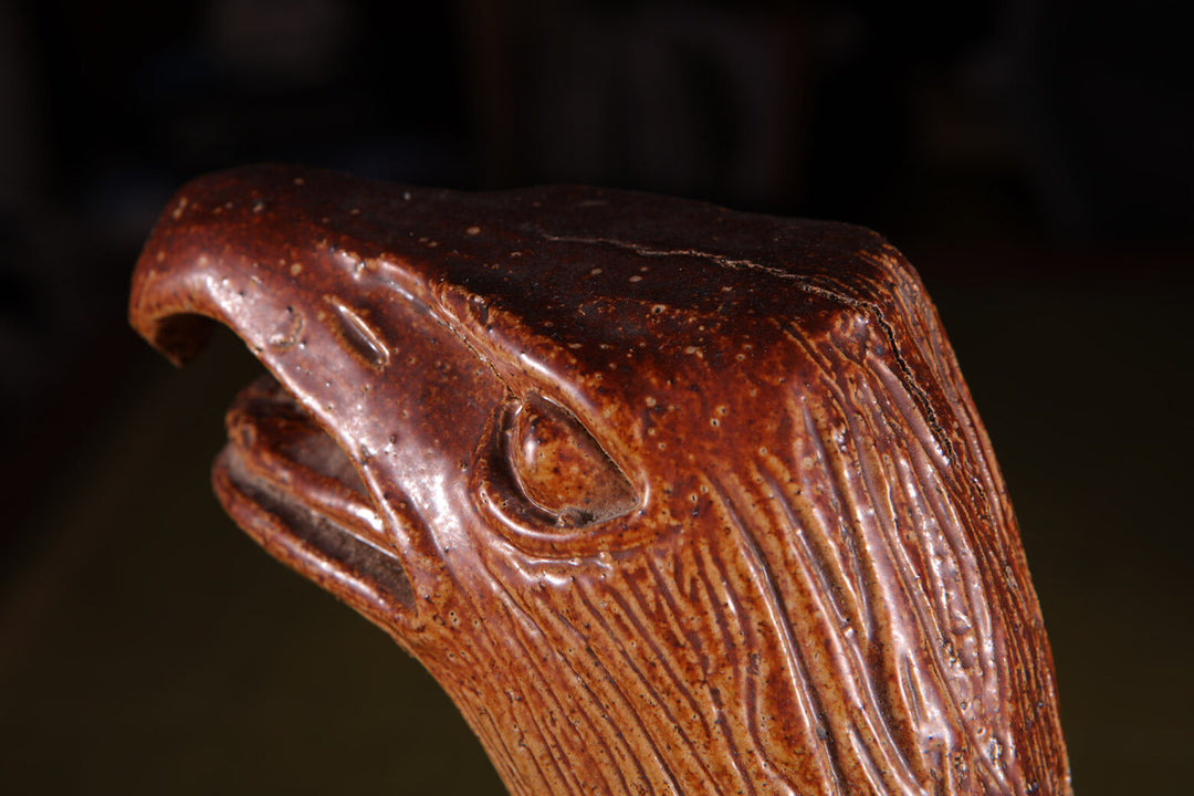 Salt Glazed Eagles close-up of 19th century pottery eagle head with incised decorated wings and open beak.