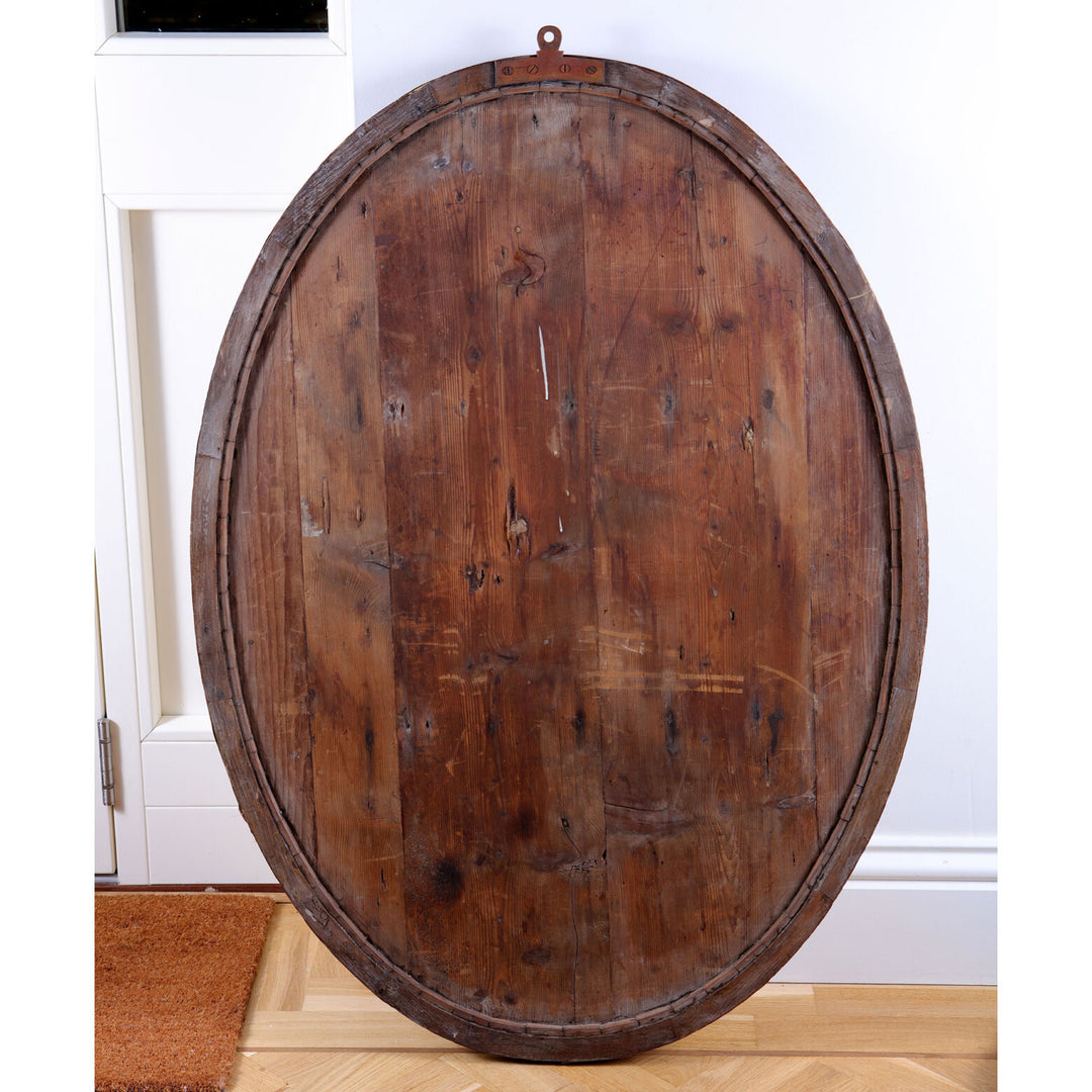 Pair of Irish Oval Lozenge Mirrors shown from the back with rustic wooden frame and oval shape against a white wall.