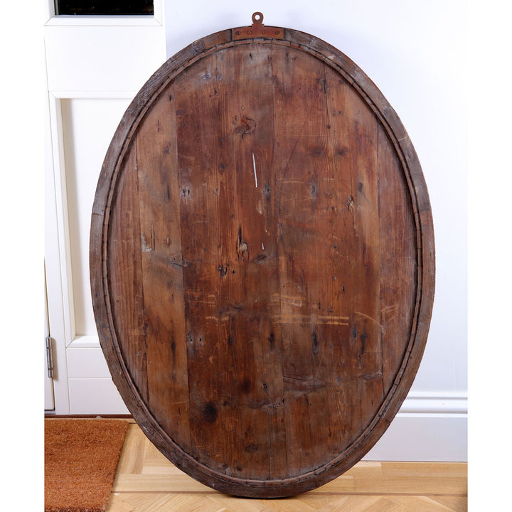 Pair of Irish Oval Lozenge Mirrors shown from the back with rustic wooden frame and oval shape against a white wall.