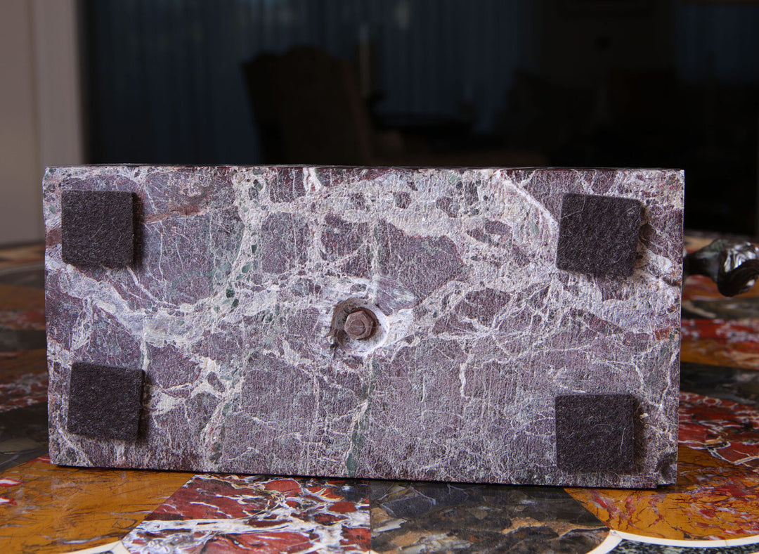 Grand Tour Equestrian Bronze marble base showing aged texture and four protective felt pads on a multicolored surface.