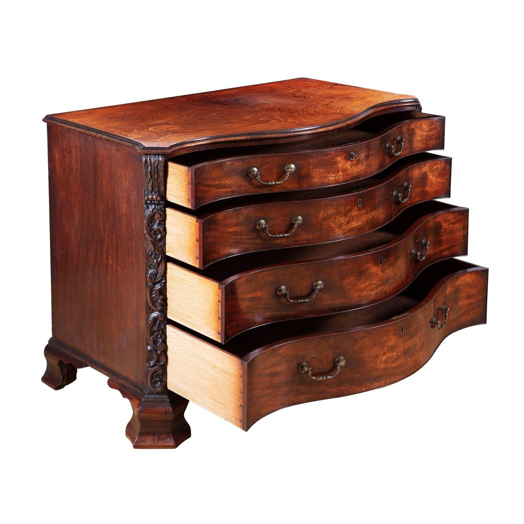 George III Chippendale Mahogany Serpentine Commode with four oak drawers and carved fruiting vine pilasters circa 1760.
