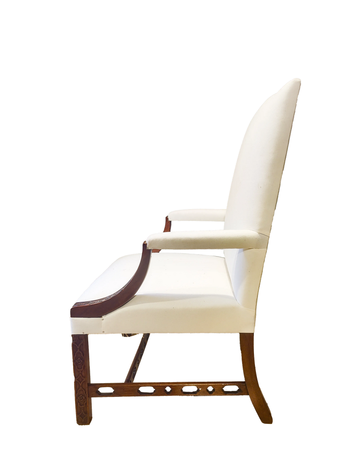 Side view of a George III library armchair with cream upholstery and carved wooden frame from Collection CK10