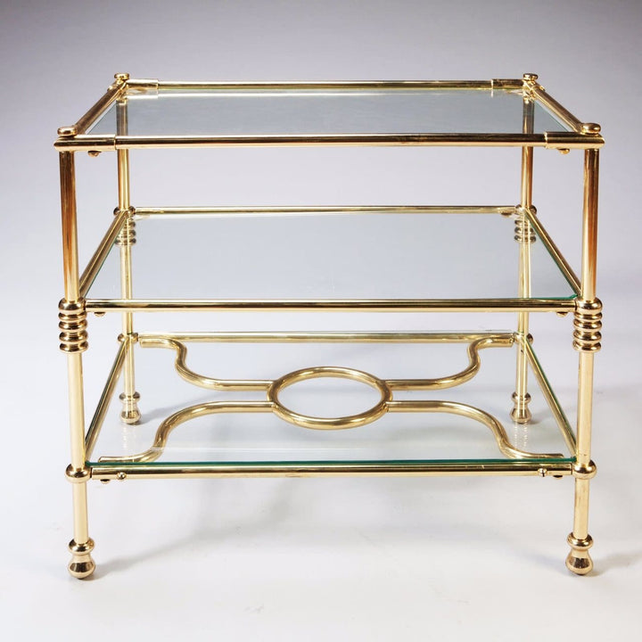 A Three Tiered Brass Art Deco Etagere with glass shelves and decorative ring supports, circa 1930 French design.