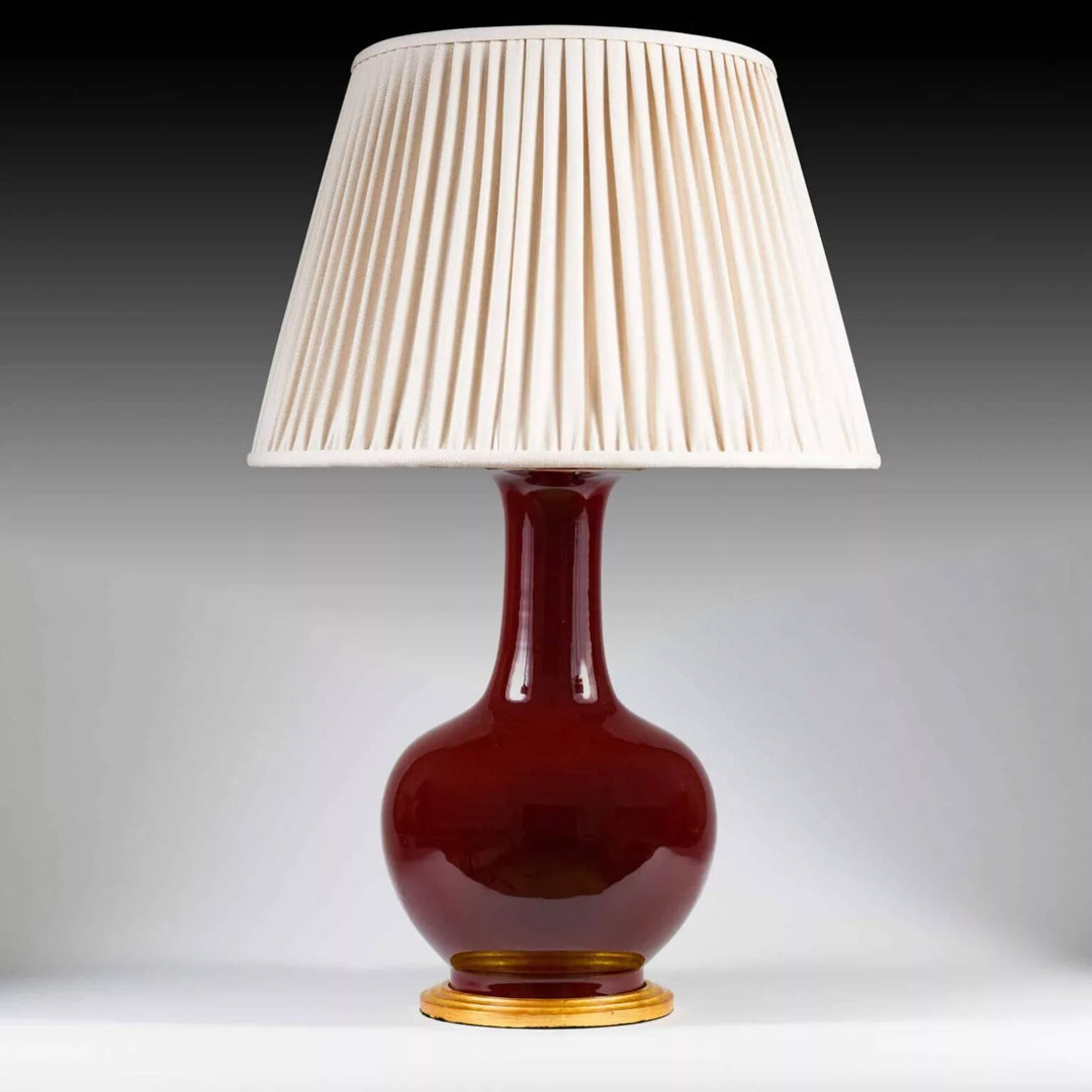 Chinese Sang de Boeuf Glazed Vase mounted as a Table lamp with pleated cream shade and gilt wooden base.
