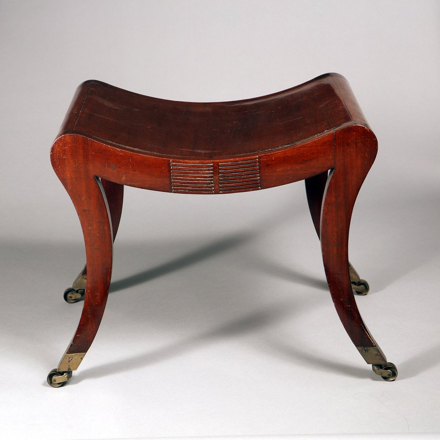 A Regency mahogany sabre legged saddle stool