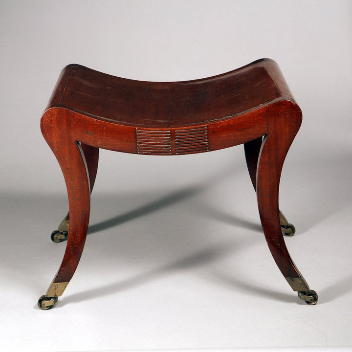 A Regency mahogany sabre legged saddle stool