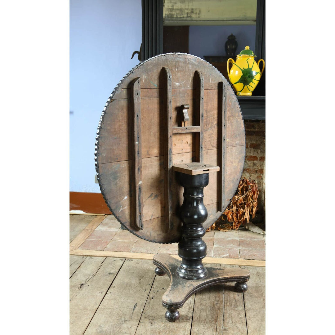 Anglo Indian Tilt Top Pedestal Centre Table showing its round wooden top and black ebonized pedestal base.