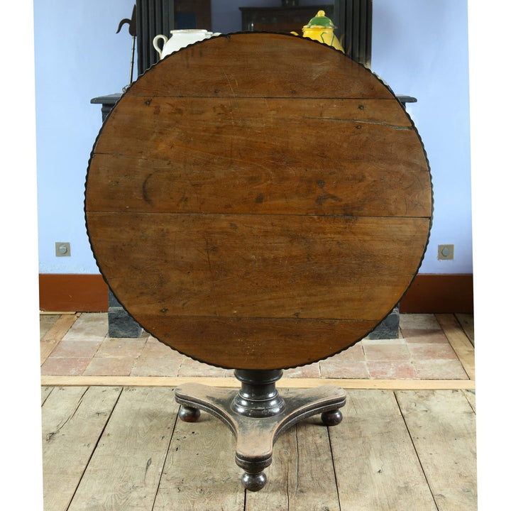 Anglo Indian Tilt Top Pedestal Centre Table with circular top and ebonized pedestal base circa 1860 in natural wood finish.
