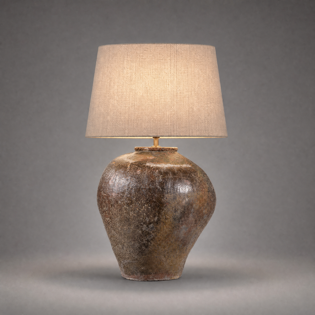 Table lamp with a textured brown base and beige lampshade on a gray background