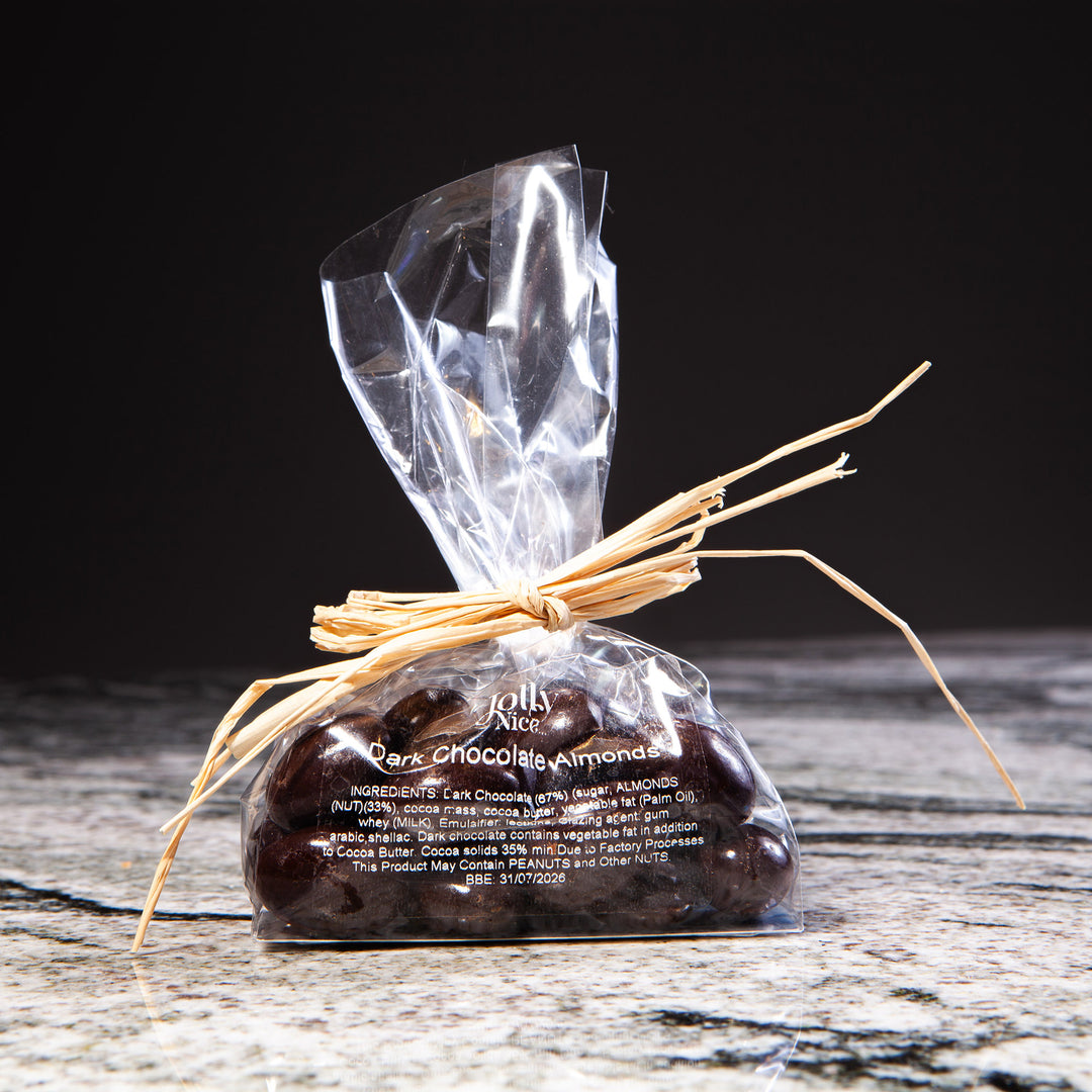 Small clear bag of dark chocolate almonds tied with natural raffia rope from Nicholas Wells Antiques Christmas Hamper 2025
