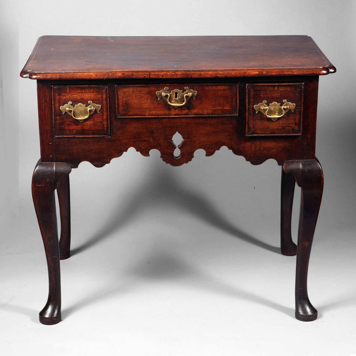 George I Oak Lowboy with three drawers, brass hardware, cabriole legs, and pierced apron, circa 1715 England.