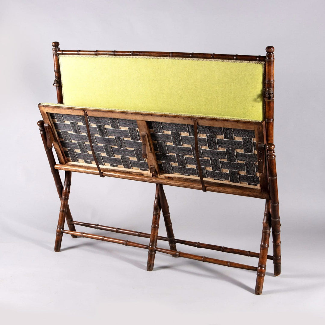 An Edwardian folding simulated bamboo Campaign settee