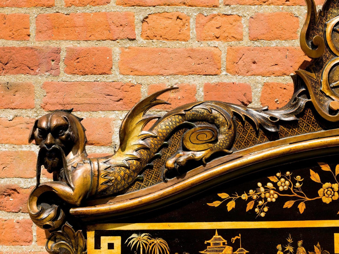 Chinoiserie Black Japanned Overmantel Mirror with gilt ribbon motif and dragon-like carved figures on black and gold frame