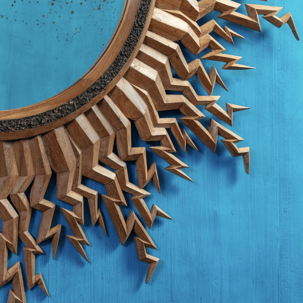 Zeus Mirror with carved wooden lightning bolt frame and antique central mirror on blue background.