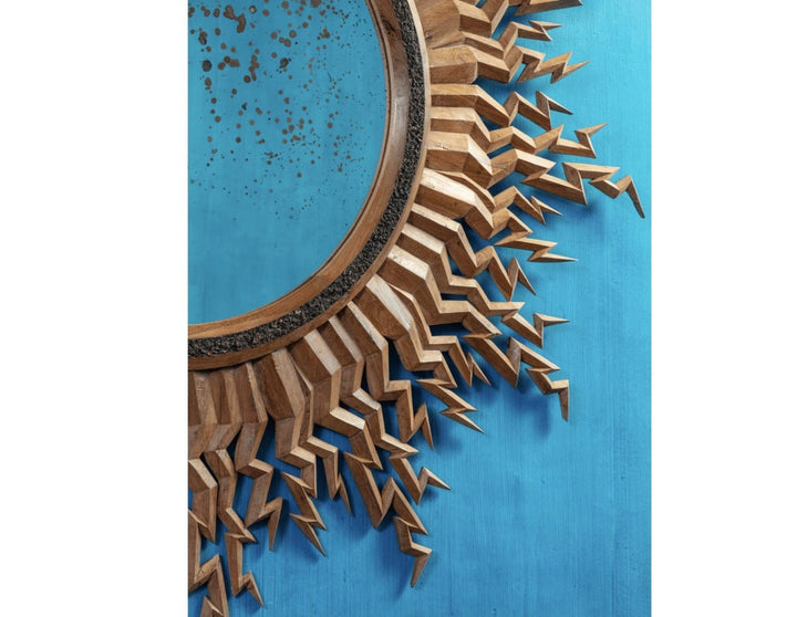 Zeus Mirror carved wooden frame with lightning bolt design and antique central round mirror on blue background