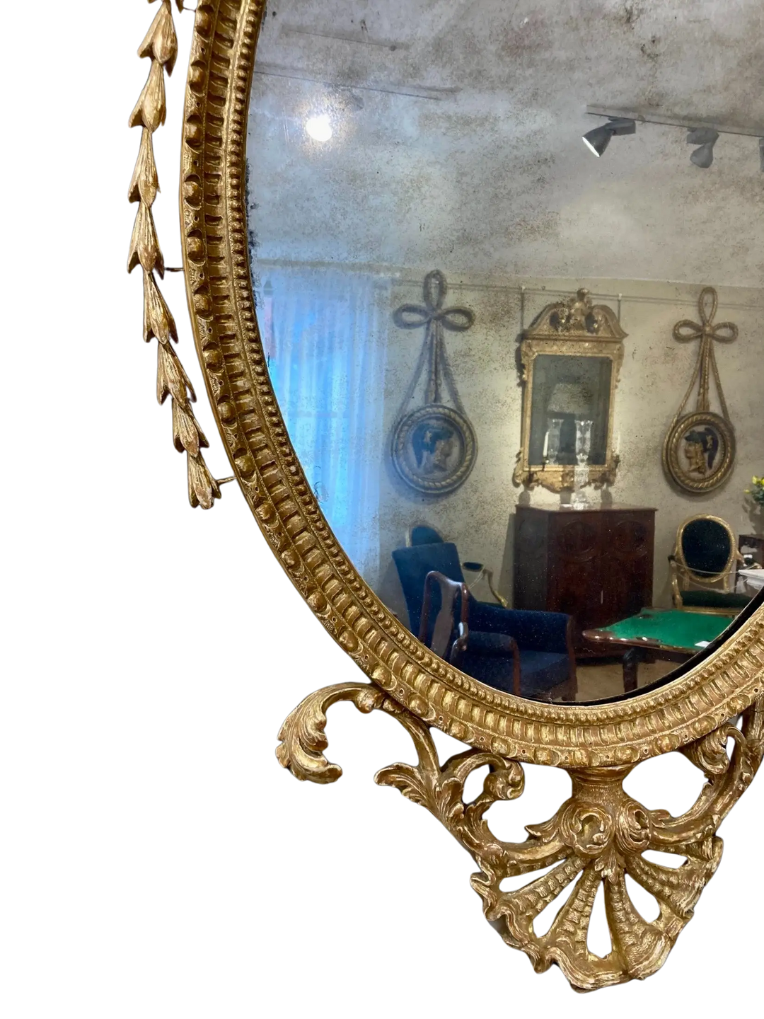 John Linnell Oval Gilt Mirror with intricate carved giltwood frame reflecting antique furnishings.