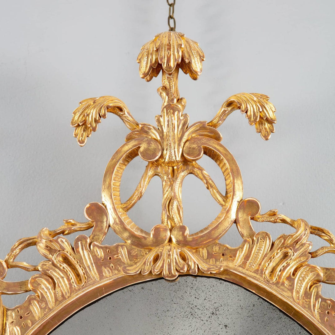 George III Rococo giltwood oval mirror with intricate C and S scrolls and Prince of Wales feathers apex detail.