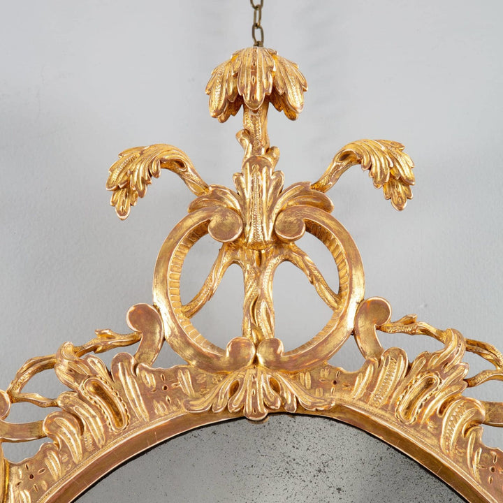George III Rococo giltwood oval mirror with intricate C and S scrolls and Prince of Wales feathers apex detail.