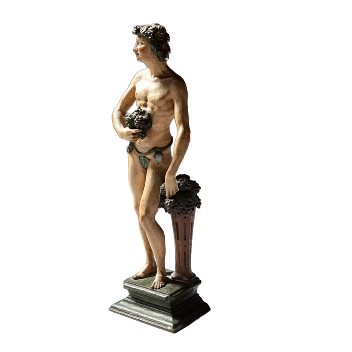 Flemish Carved Wooden Polychrome Figure Of Bacchus, 17th century sculpture of Roman god holding grapes on plinth.