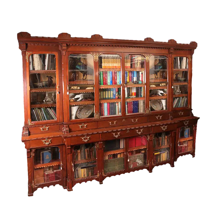 Arts and Crafts Breakfront Bookcase made of English Oak with glass doors, drawers, and ornate metal mounts.