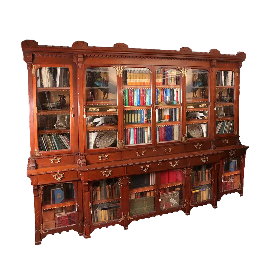 Arts and Crafts Breakfront Bookcase made of English Oak with glass doors, drawers, and ornate metal mounts.