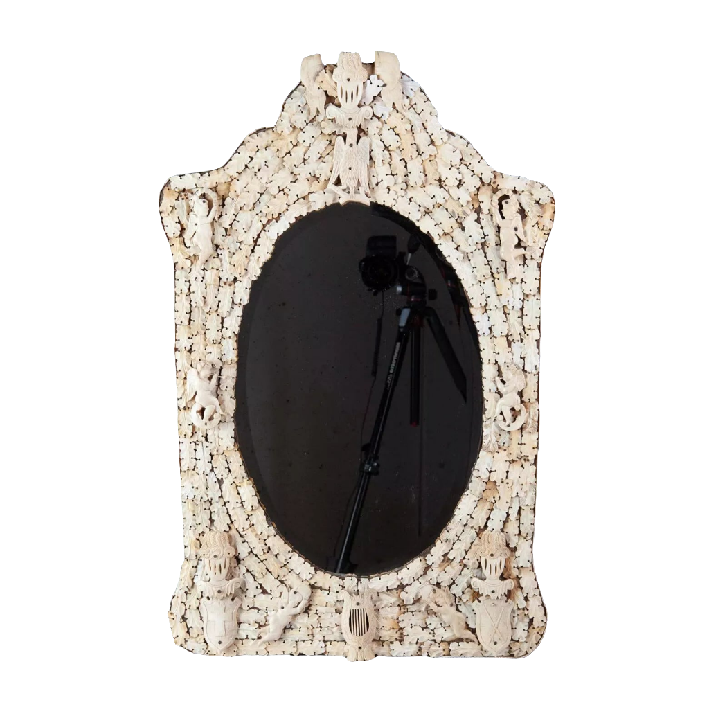 Dieppe Bone Mirror with intricate carved whale bone frame featuring cherubs, knights, and flags, circa 1830, oval beveled glass.