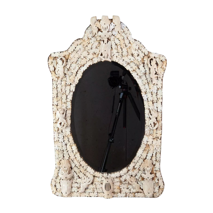 Dieppe Bone Mirror with intricate carved whale bone frame featuring cherubs, knights, and flags, circa 1830, oval beveled glass.