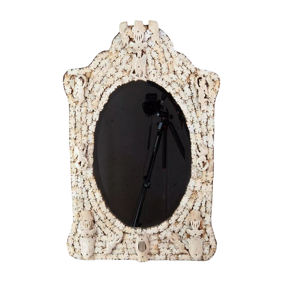 Dieppe Bone Mirror with intricate carved whale bone frame featuring cherubs, knights, and flags, circa 1830, oval beveled glass.