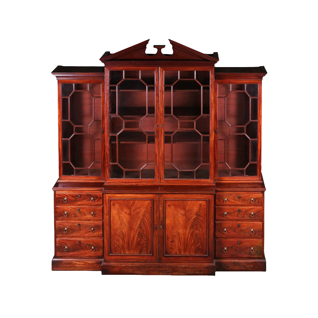 GEORGE III MAHOGANY BREAKFRONT BOOKCASE with glazed doors, drawers, and carved broken pediment circa 1770 England.