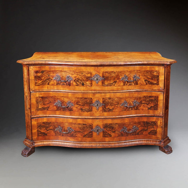 Early 18th Century Italian Walnut Commode with three drawers, rococo handles, parquet top, and carved paw feet.