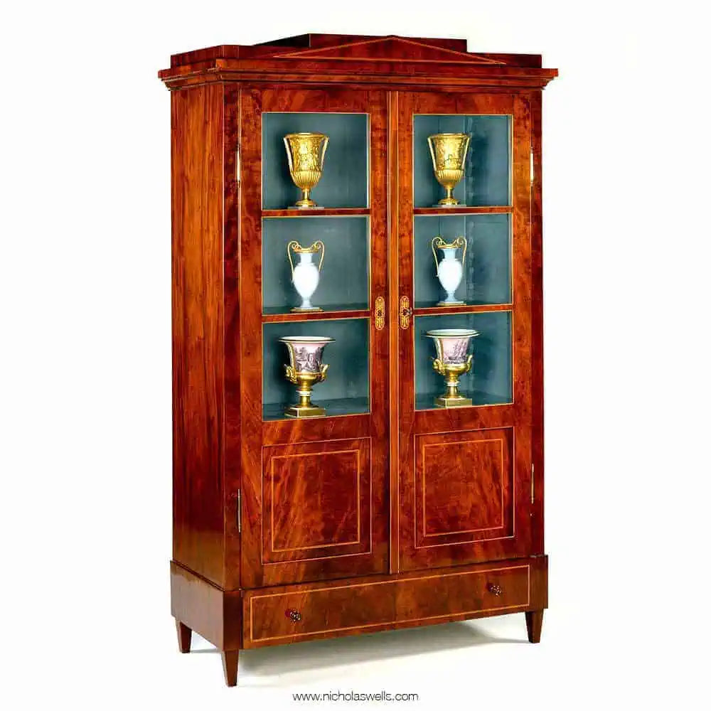 Early 19th Century Berlin Mahogany Armoire with stepped pediment, glazed doors, flame veneer, and painted interior.