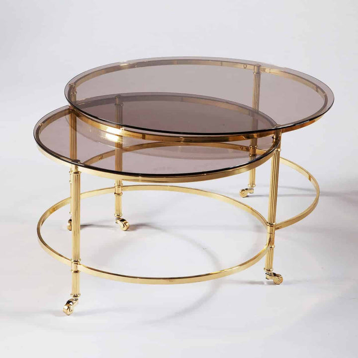 Mid Century Metamorphic Brass Coffee Table with polished brass frame and smoked glass tops on wheels for mobility.