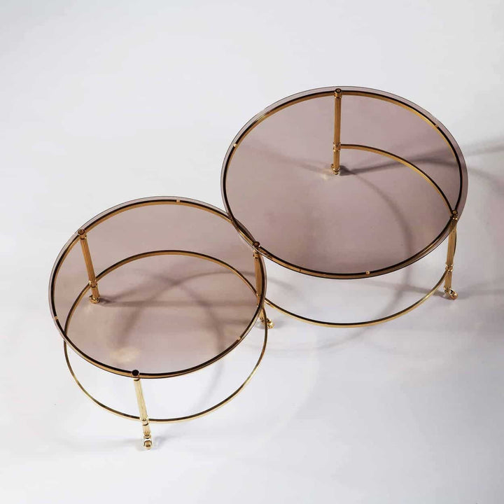 Mid Century Metamorphic Brass Coffee Table with circular smoked glass tops and burnished brass reeded legs on casters.