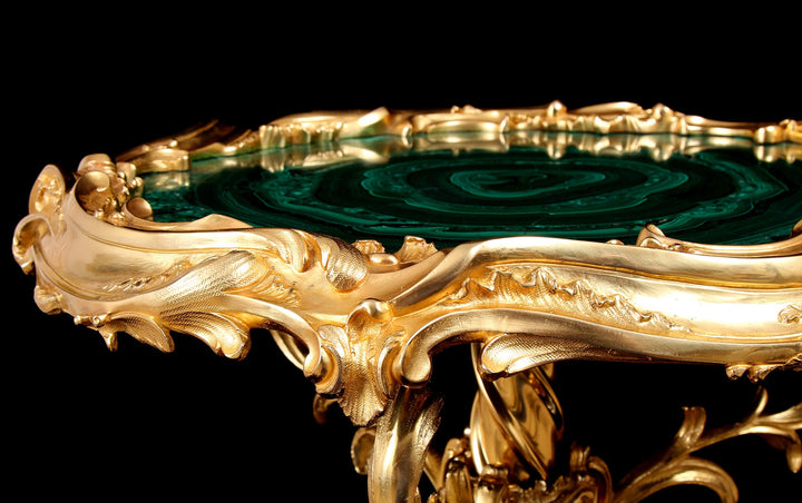 Rococo Ormolu | Malachite Table with gilded bronze frame and intricate ‘C’ scrolled and acanthus leaf motifs on black background.