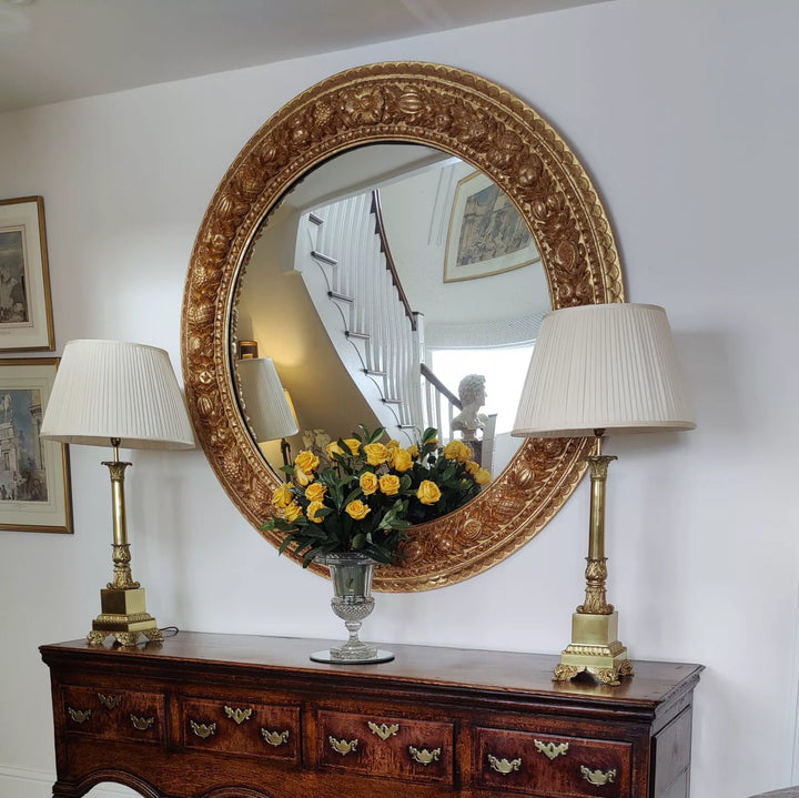 Monumental 5ft Round Italian Mirror with carved giltwood frame featuring fruits and foliage, 19th century Italy.