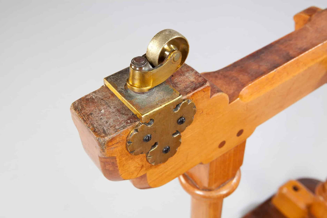 Close-up of the Arts And Crafts Writing Table By Marsh And Jones showing turned columns and brass trefoil casters.